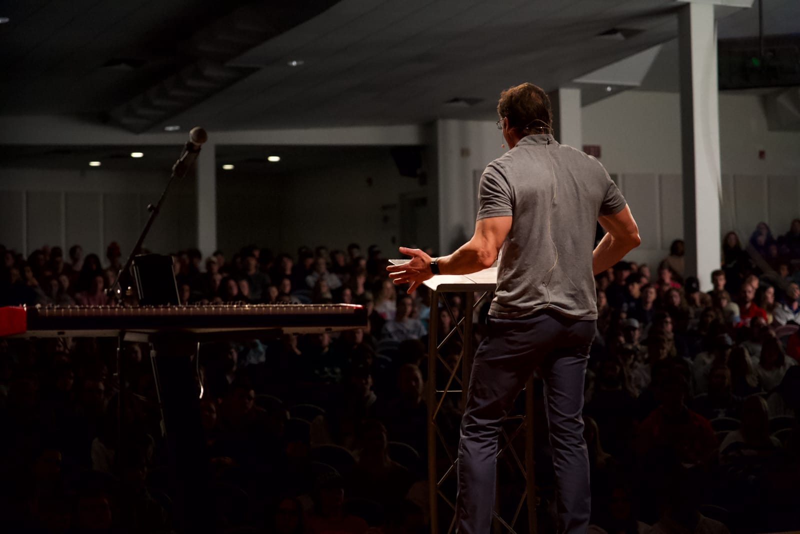 Dan Cruver speaking to a packed auditorium, seen from behind